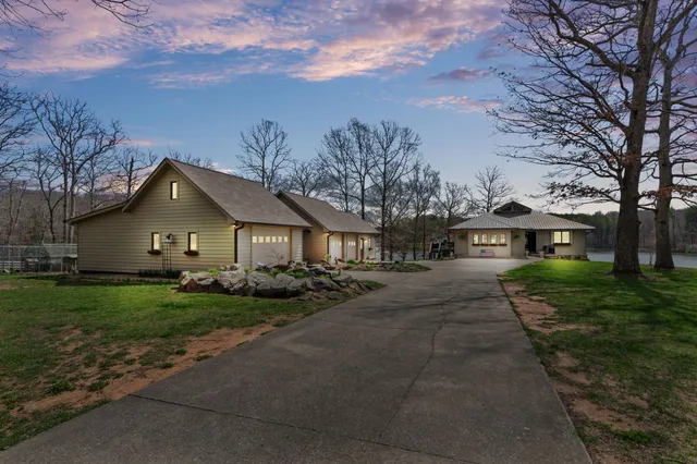 a view of a house with a yard and large trees