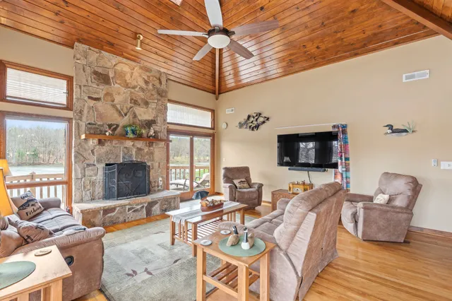 a living room with furniture a flat screen tv and a large window