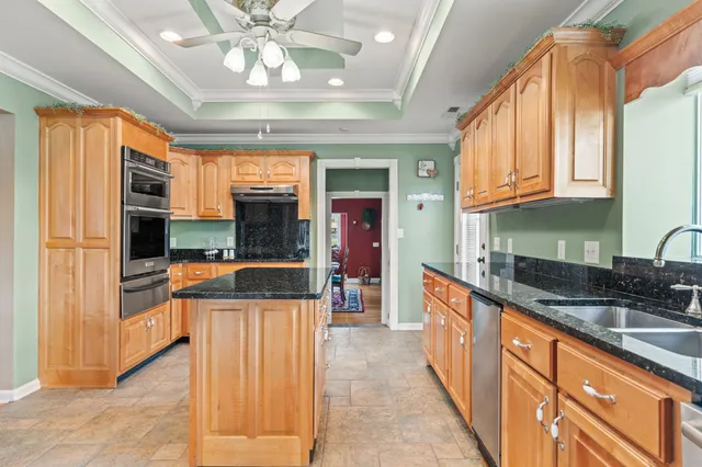 a kitchen with stainless steel appliances granite countertop a sink a stove and cabinets