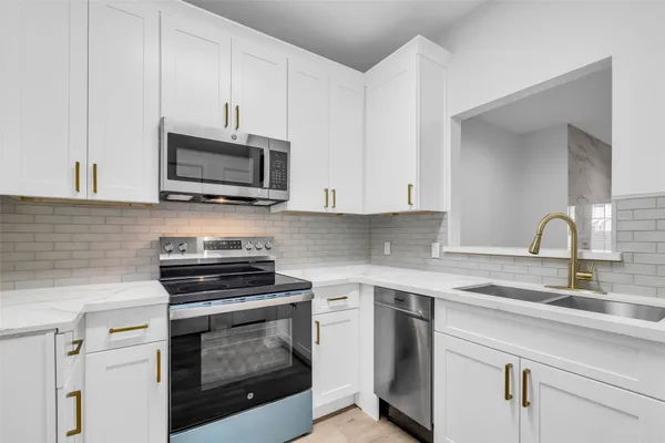 a kitchen with cabinets stainless steel appliances and a sink