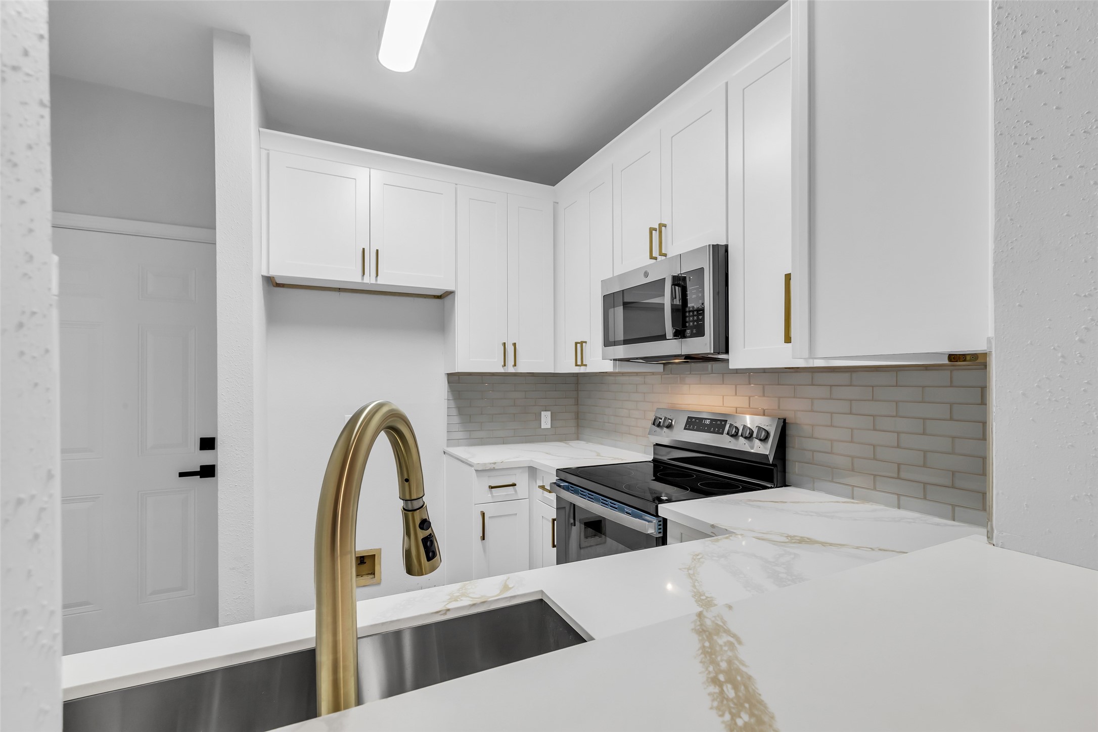 4900 Floyd Street, Unit 10 Houston, TX 77007 - Photo 14 of 30 a kitchen with stainless steel appliances a stove microwave and sink