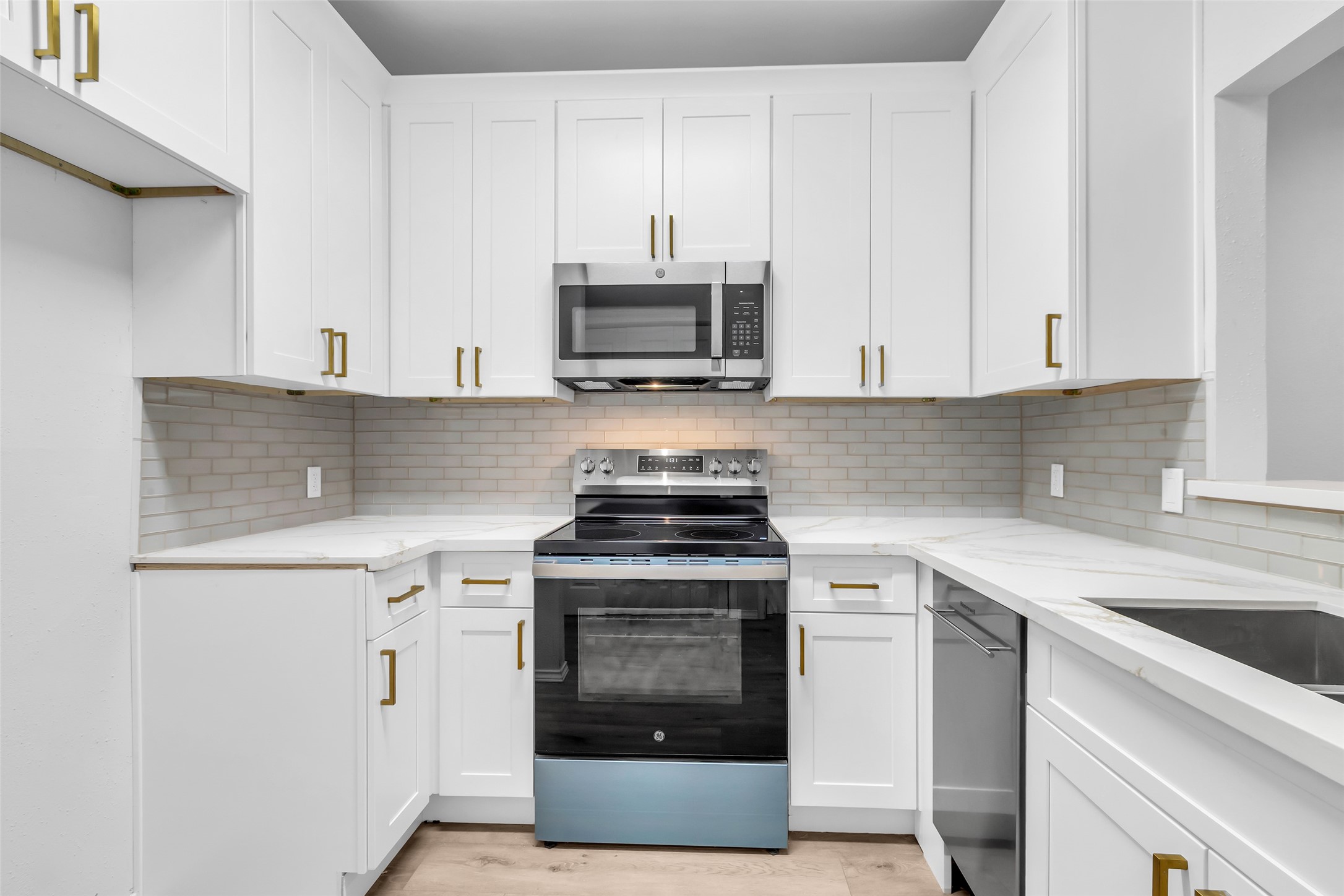 4900 Floyd Street, Unit 10 Houston, TX 77007 - Photo 15 of 30 a kitchen with stainless steel appliances granite countertop white cabinets a stove a sink and dishwasher