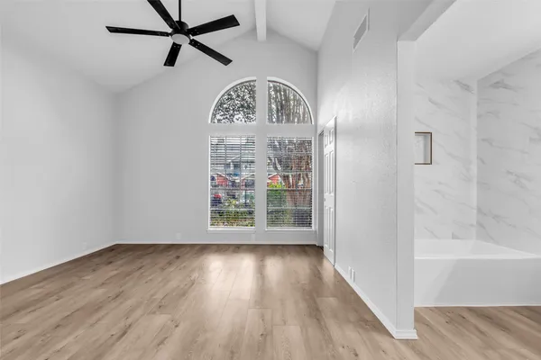 a view of a hallway with wooden floor and a chandelier