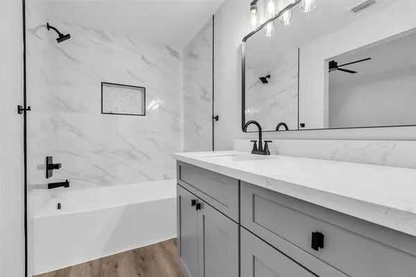 a bathroom with a sink a mirror and a bathtub