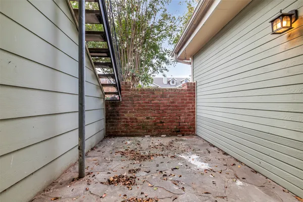 a view of a pathway of a house with wooden fence