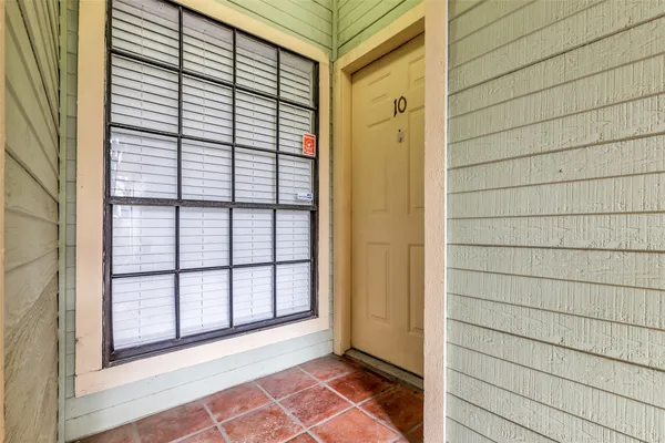 a view of a porch with a door and wooden floor