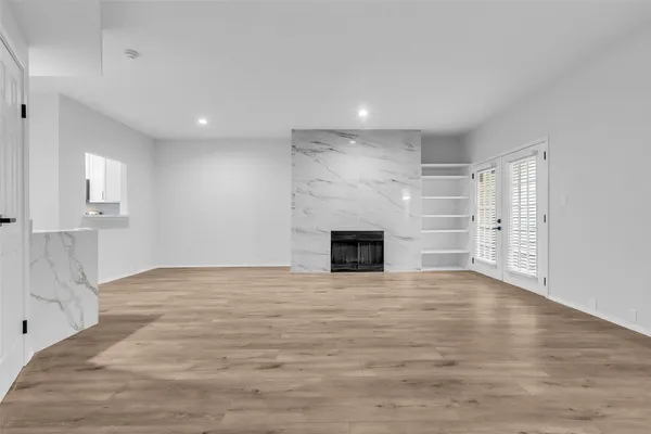 a view of empty room with wooden floor and fireplace