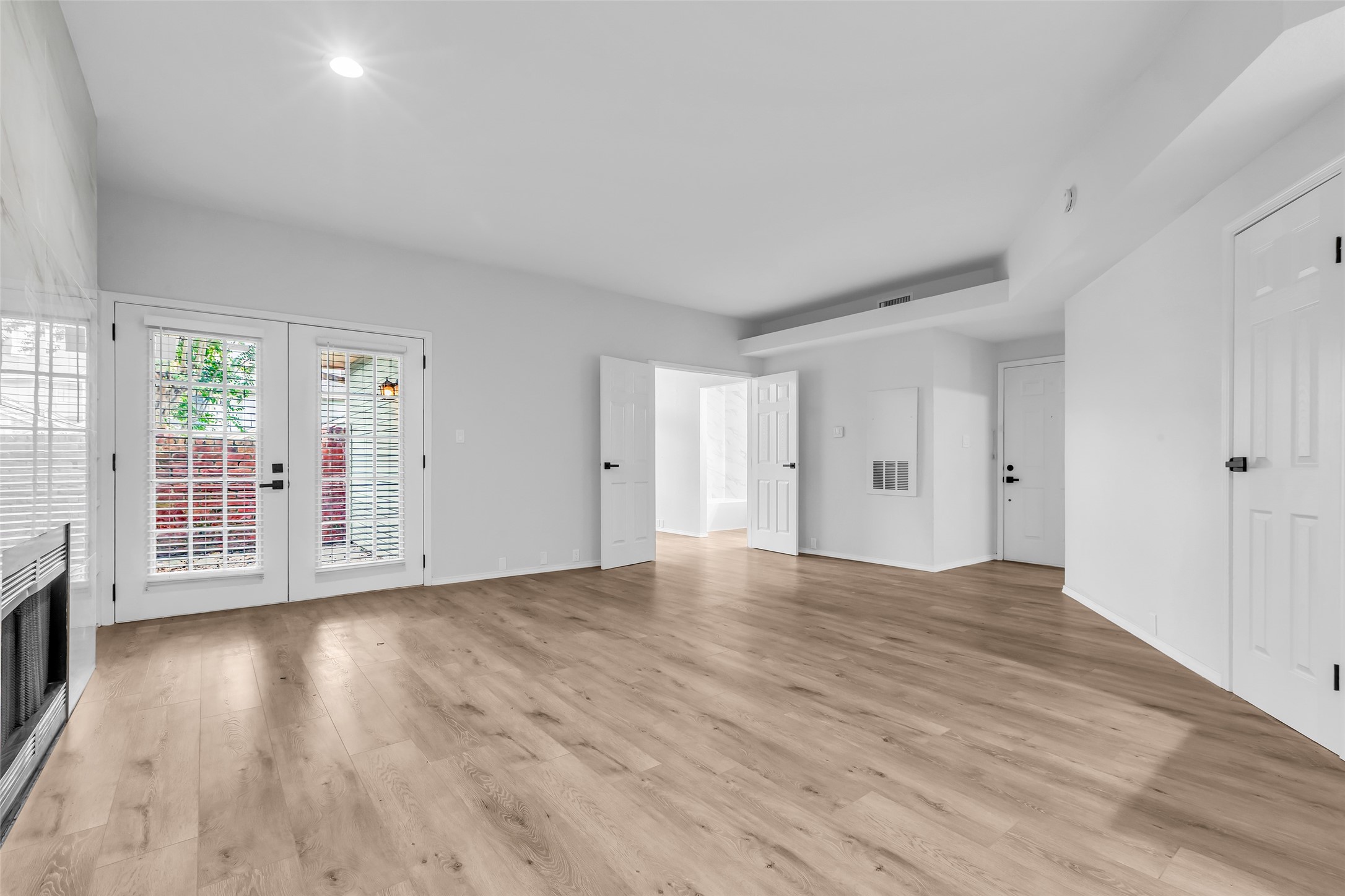 4900 Floyd Street, Unit 10 Houston, TX 77007 - Photo 6 of 30 a view of an empty room with wooden floor and a window