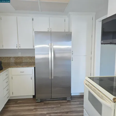 a kitchen with a refrigerator and white cabinets