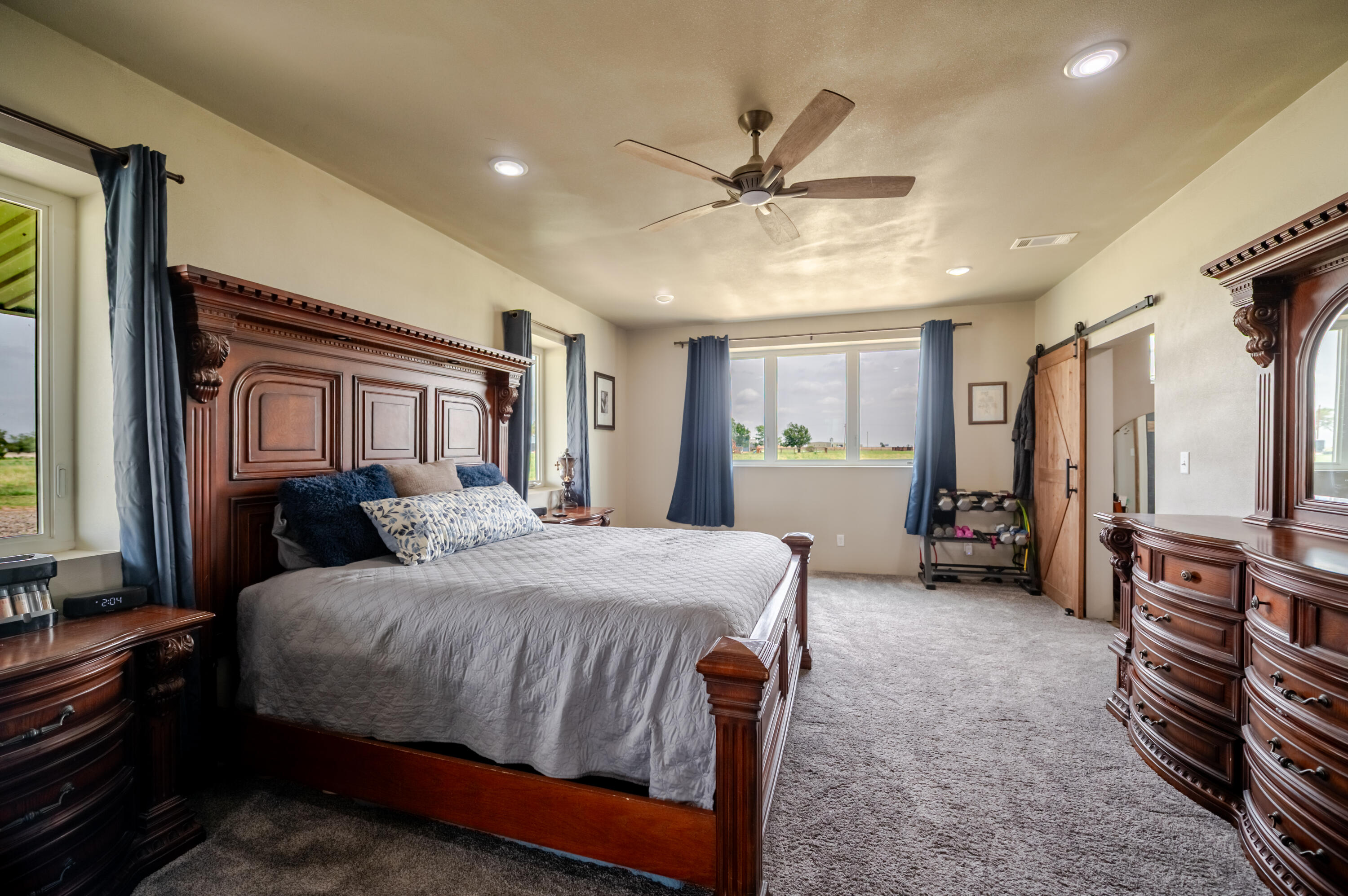 6792 Maine Road Anton, TX 79313 - Photo 26 of 77 a bedroom with a bed a chandelier and a dresser