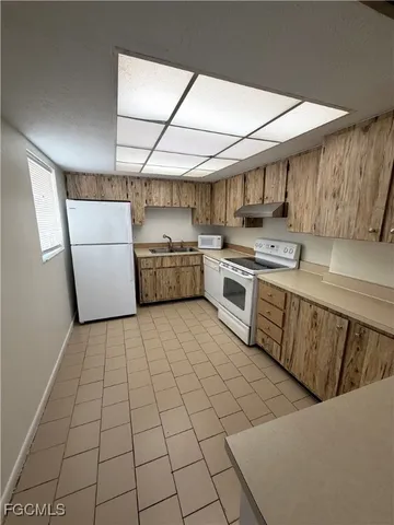 a kitchen with a sink a stove and cabinets