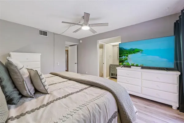 a bedroom with a large bed and a flat screen tv