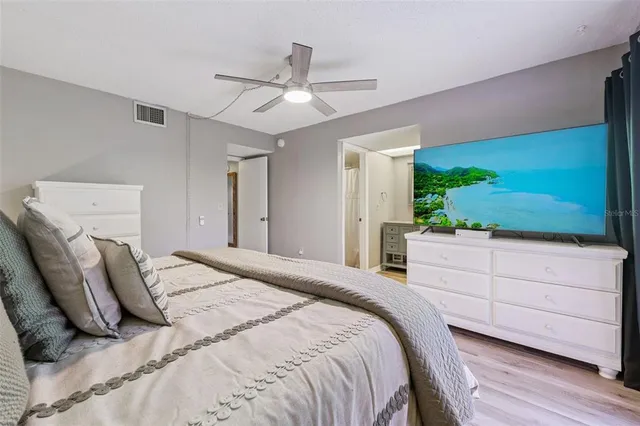 a bedroom with a large bed and a flat screen tv