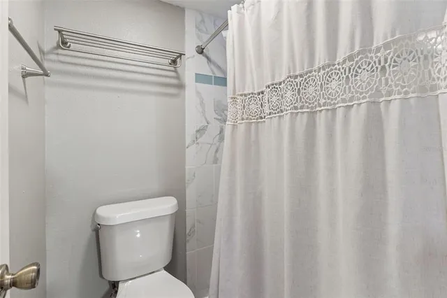 a white toilet sitting next to a shower