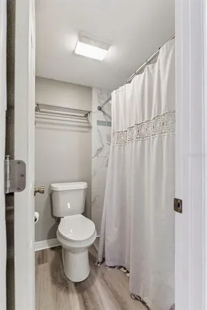 a white toilet sitting next to a shower
