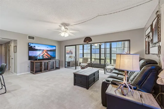 a living room with furniture ceiling fan and a flat screen tv