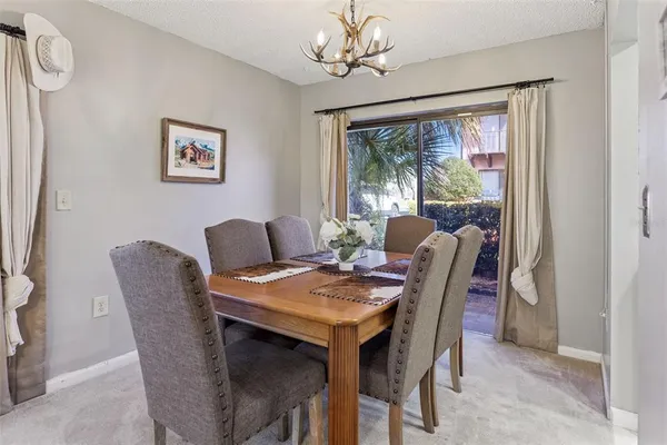 a view of a dining room with furniture a chandelier and a window