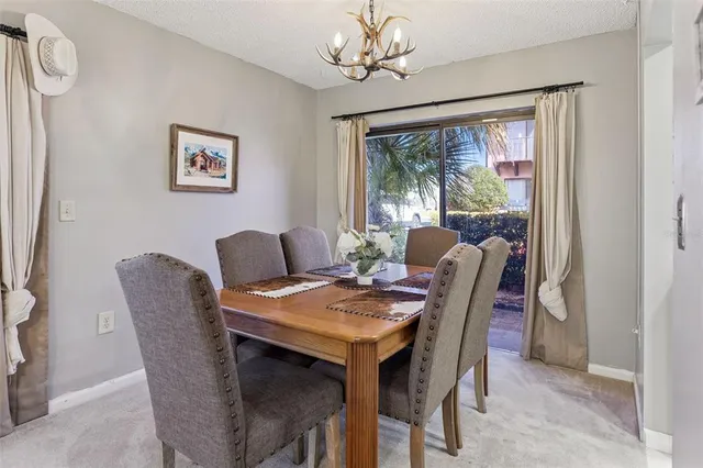a view of a dining room with furniture a chandelier and a window