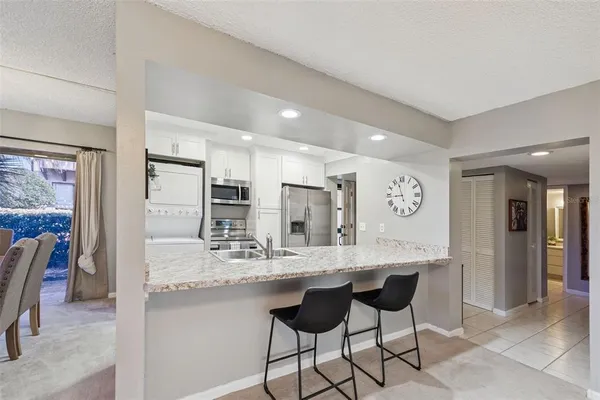 a kitchen with kitchen island granite countertop a sink and cabinets