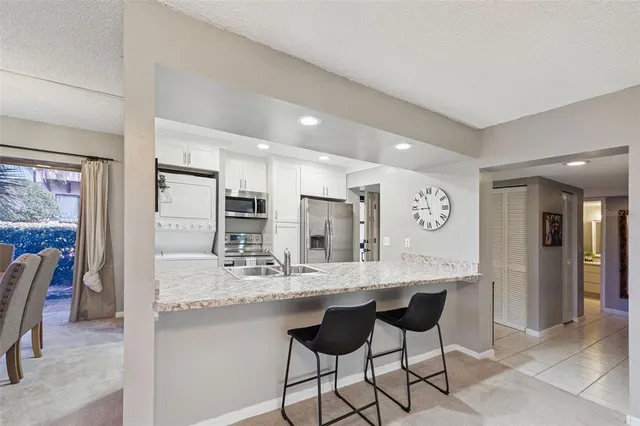 a kitchen with kitchen island granite countertop a sink and cabinets