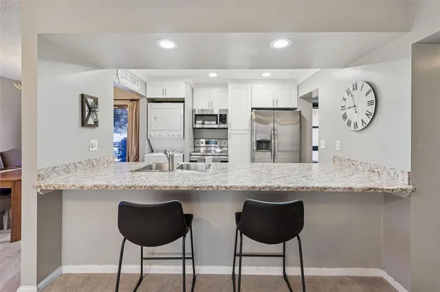 a kitchen with cabinets and chairs