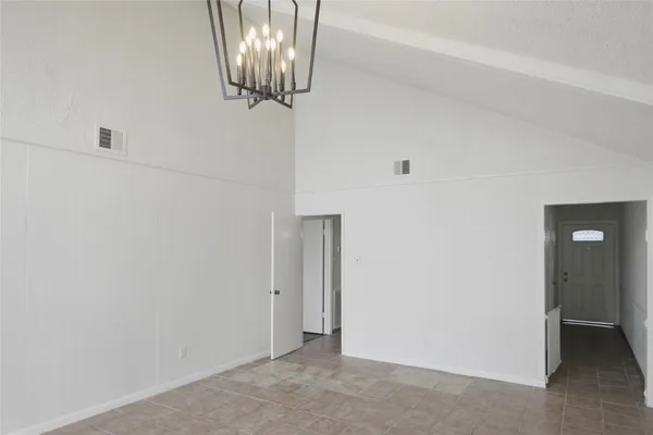 a view of empty room with chandelier fan
