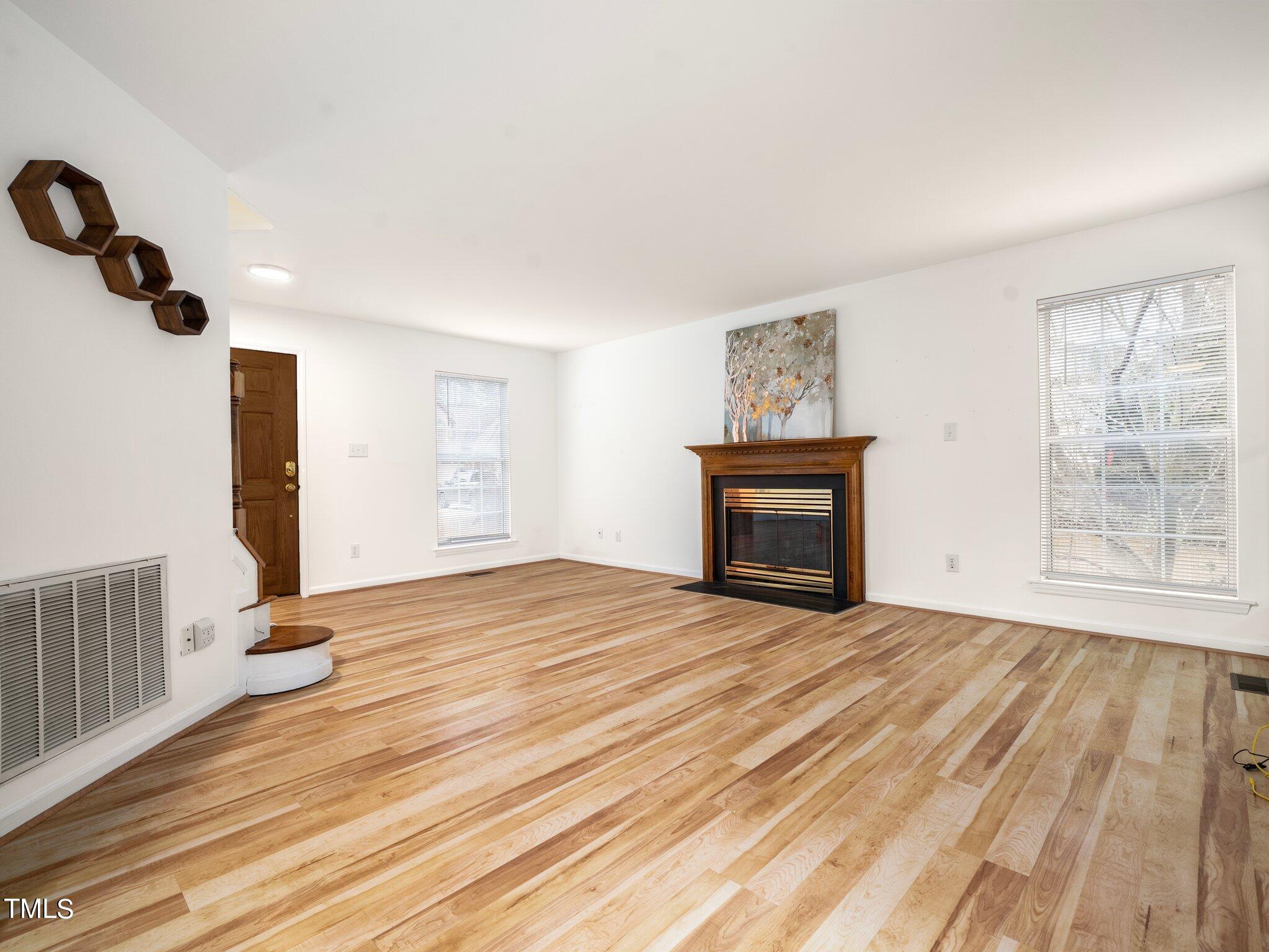 112 Riva Trace Drive Cary, NC 27513 - Photo 5 of 29 a view of empty room with a fireplace and wooden floor