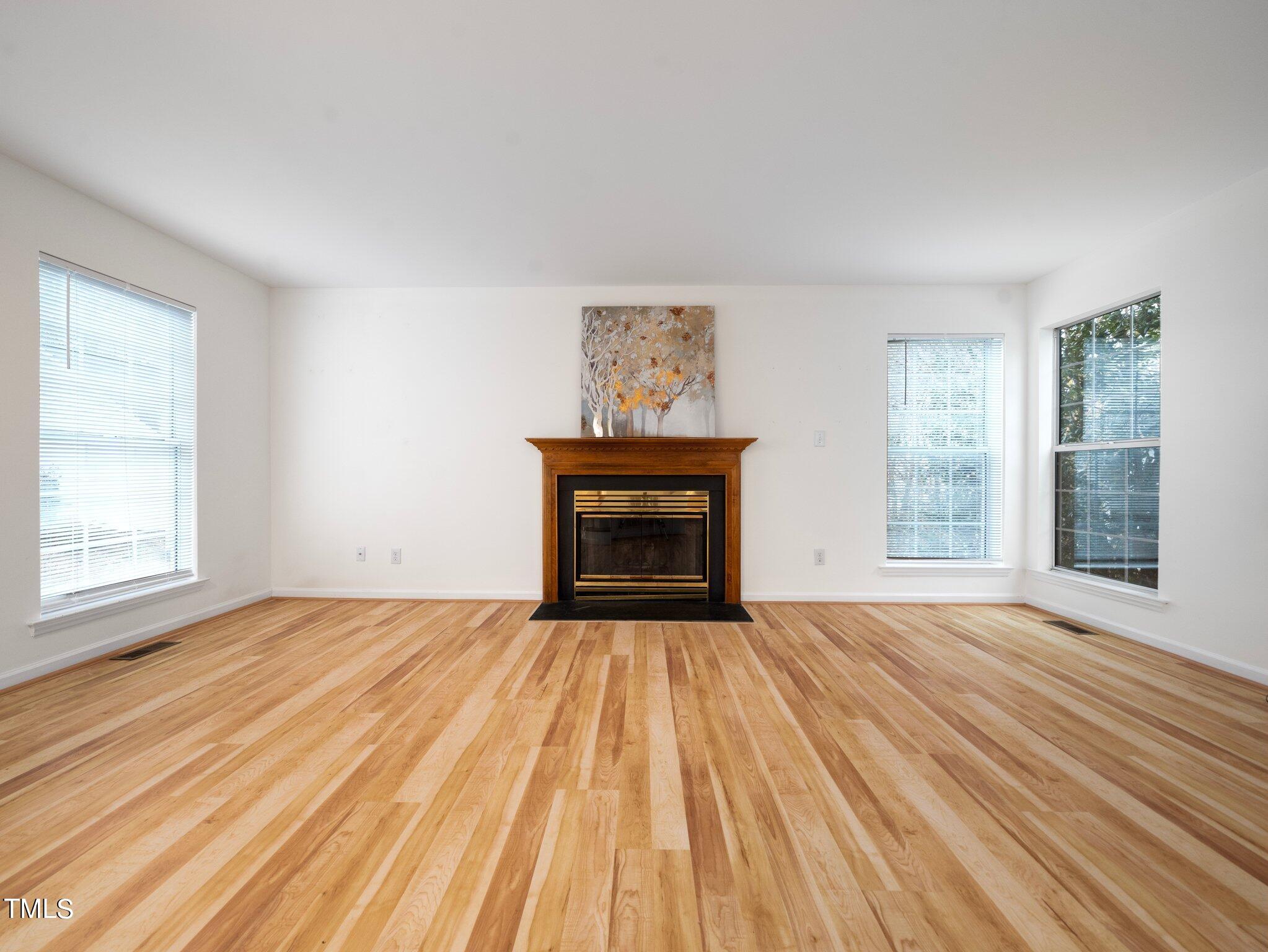 112 Riva Trace Drive Cary, NC 27513 - Photo 6 of 29 a view of an empty room with wooden floor fireplace and a window