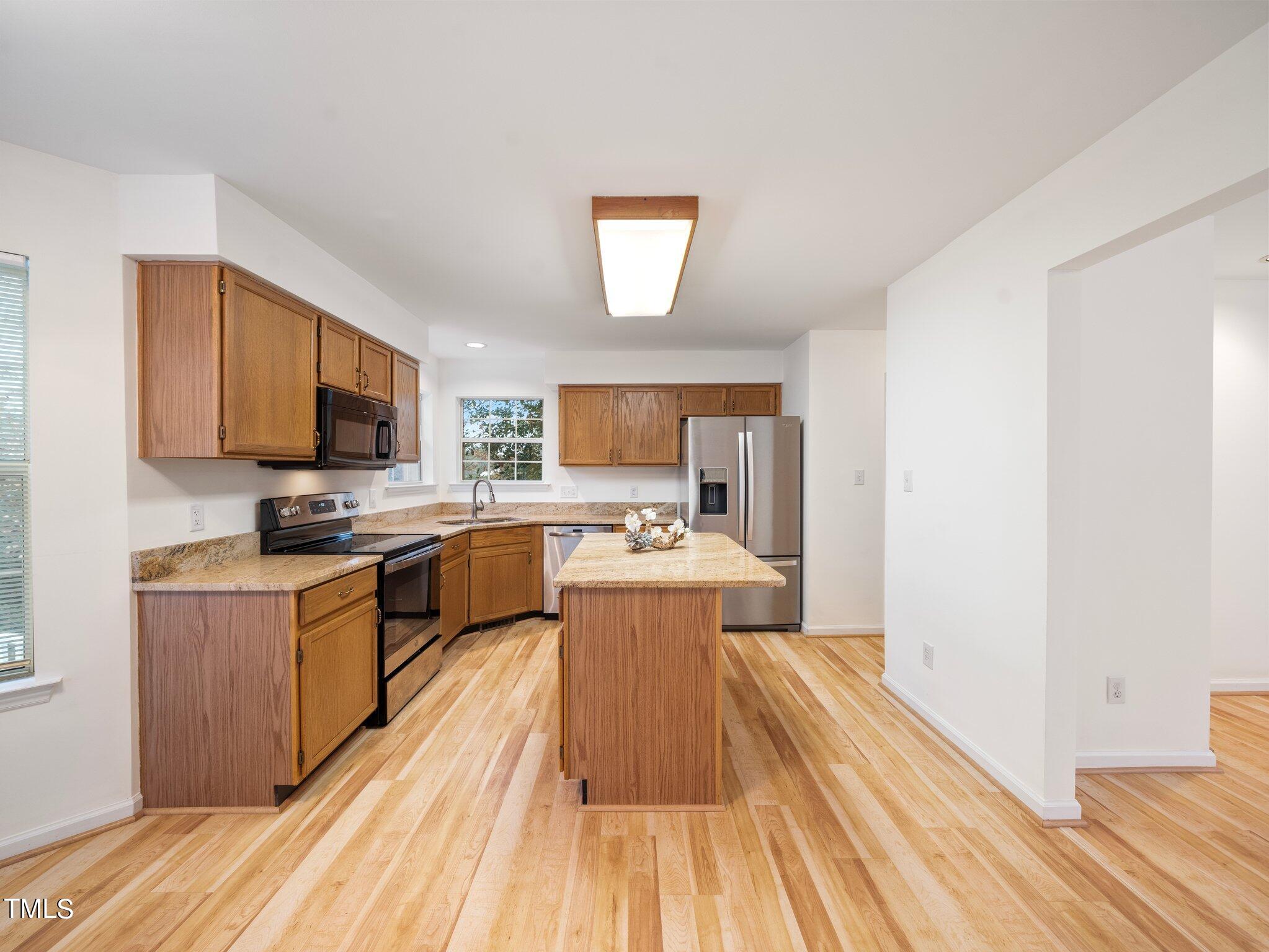 112 Riva Trace Drive Cary, NC 27513 - Photo 8 of 29 a kitchen with stainless steel appliances a stove top oven a sink dishwasher and a refrigerator with wooden floor