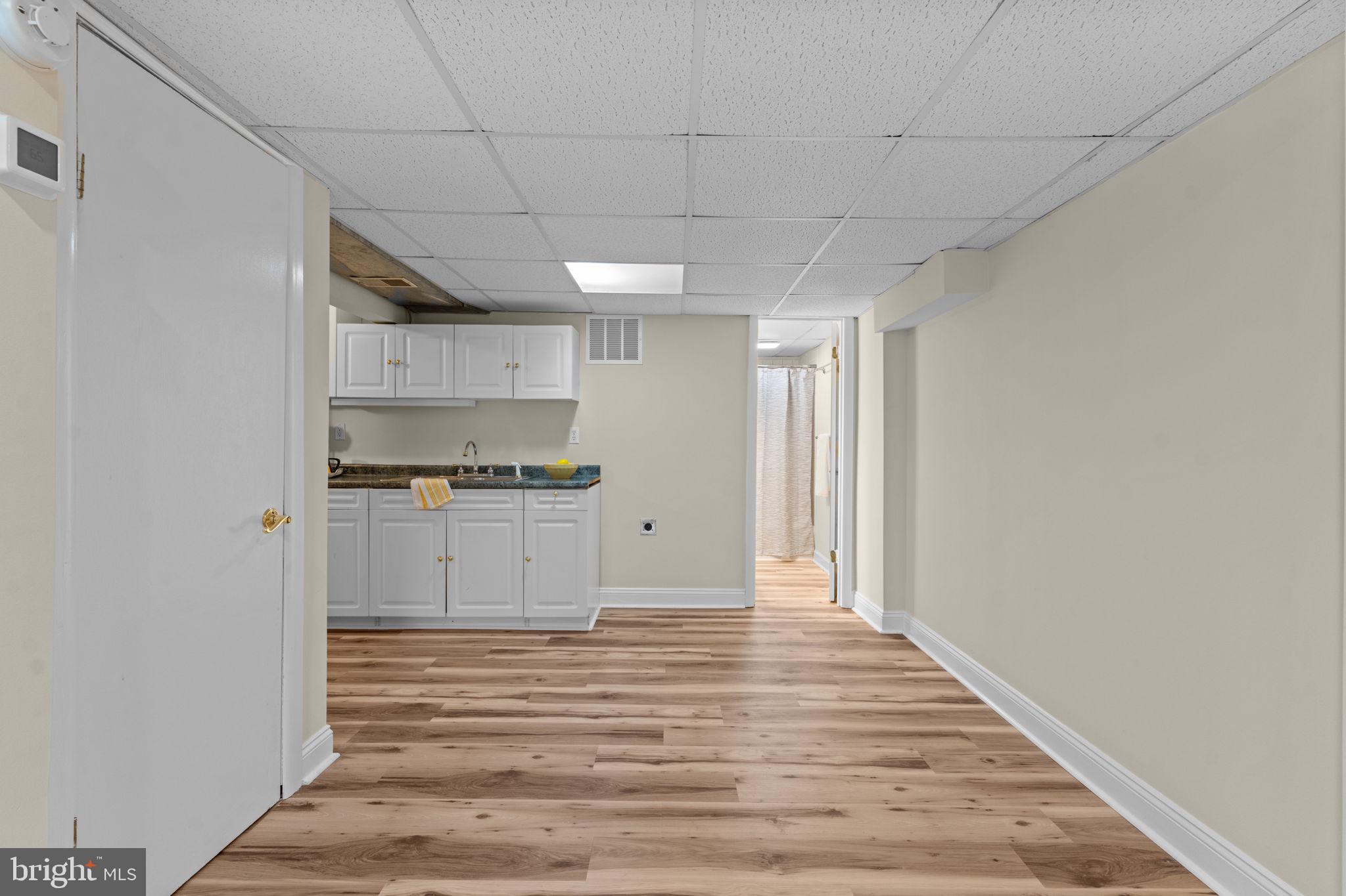 11492 Rawhide Road Lusby, MD 20657 - Photo 45 of 96 a view of kitchen and empty room with wooden floor