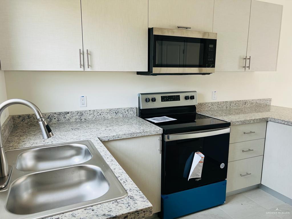 1201 West Garfield Avenue, Unit 3 Alton, TX 78573 - Photo 4 of 15 a kitchen with stainless steel appliances granite countertop a sink and a stove