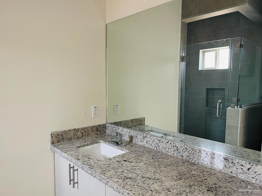 1201 West Garfield Avenue, Unit 3 Alton, TX 78573 - Photo 7 of 15 a bathroom with a granite countertop sink and a mirror