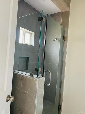 a bathroom with a shower and a mirror
