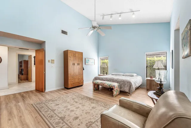 a bedroom with a large bed a flat tv screen and dresser