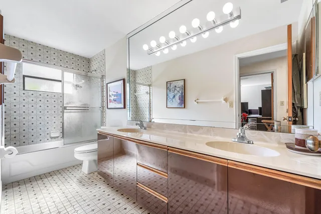 a bedroom with a bed and a flat tv screen on dresser