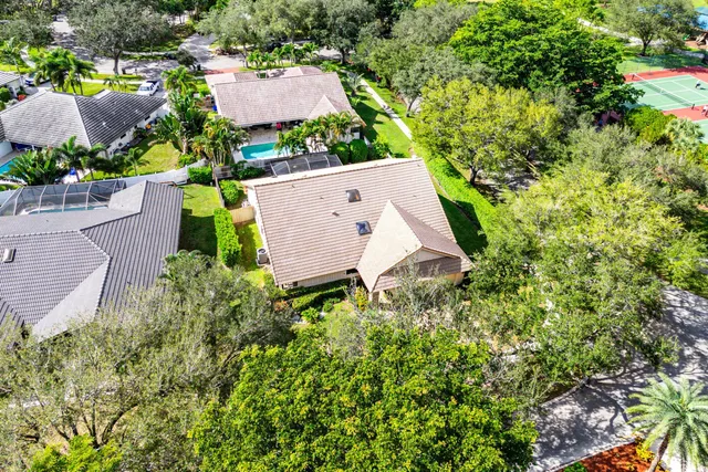 an aerial view of residential houses with outdoor space and trees
