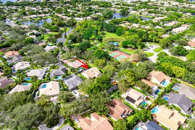 a sign of golf club on a wall under a tree