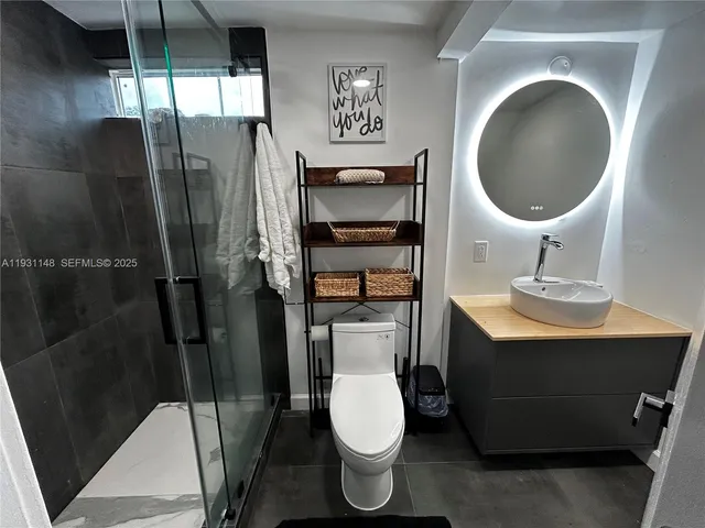 a bathroom with a toilet a sink and mirror