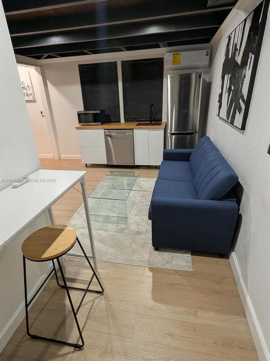 2809 Southwest 8th Street, Unit B Fort Lauderdale, FL 33312 - Photo 8 of 24 a living room with furniture and a flat screen tv