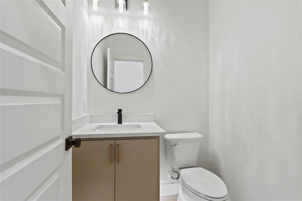 2404 52nd Street Dallas, TX 75216 - Photo 4 of 21 a bathroom with a toilet a sink and a mirror