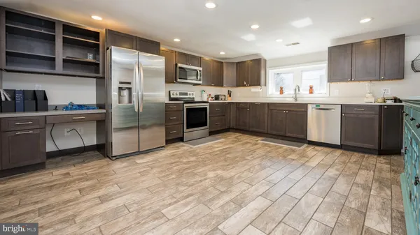 a kitchen with stainless steel appliances a stove a refrigerator and a sink