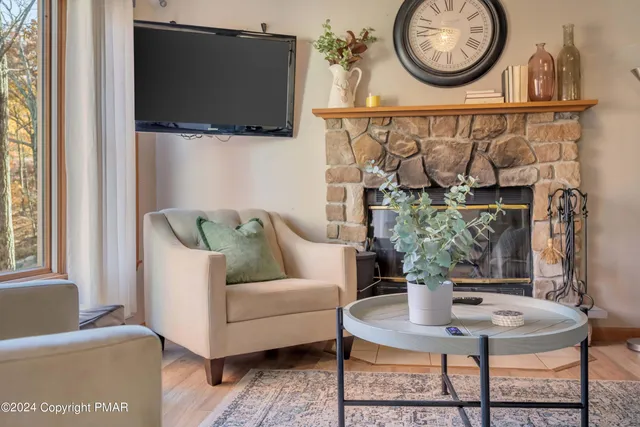 a living room with furniture a flat screen tv and a window