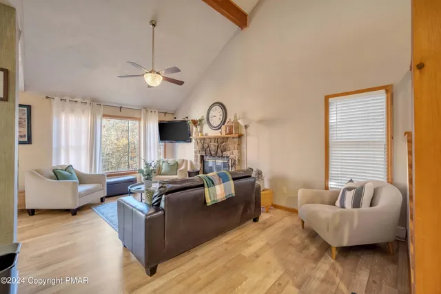 a living room with fireplace furniture and a large window