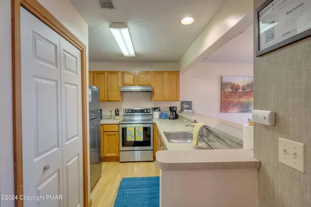 a kitchen with stainless steel appliances granite countertop a sink and a stove top oven