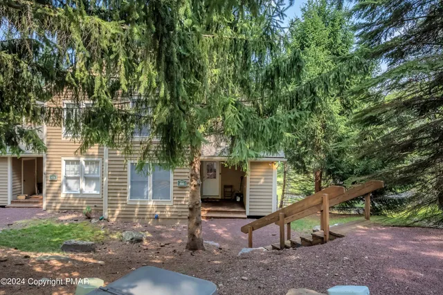 a view of a house with backyard and a tree
