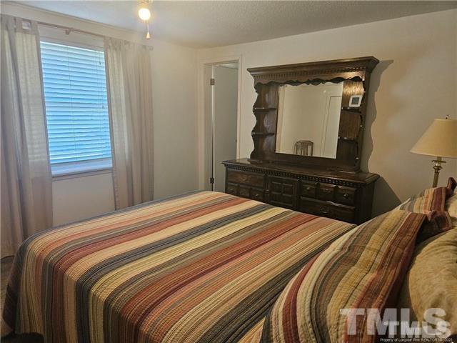 2164 Ray Road Spring Lake, NC 28390 - Photo 11 of 17 a bedroom with a bed and a mirror on dresser