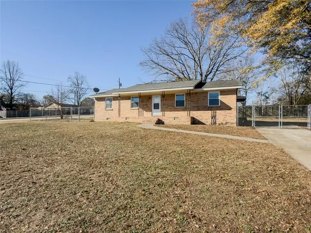 a view of a house with backyard and trees