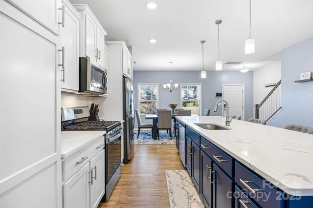 a kitchen with stainless steel appliances kitchen island granite countertop a stove a sink and a refrigerator