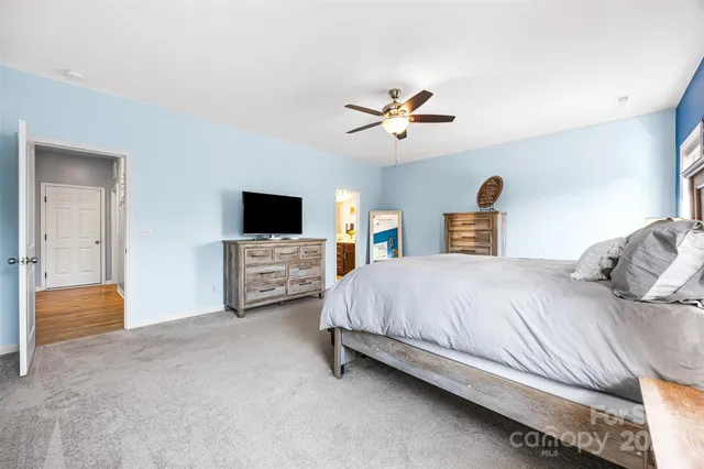 a spacious bedroom with a bed and a flat screen tv