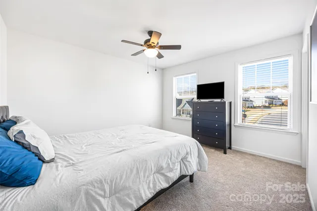 a bedroom with a bed dresser and a flat tv screen